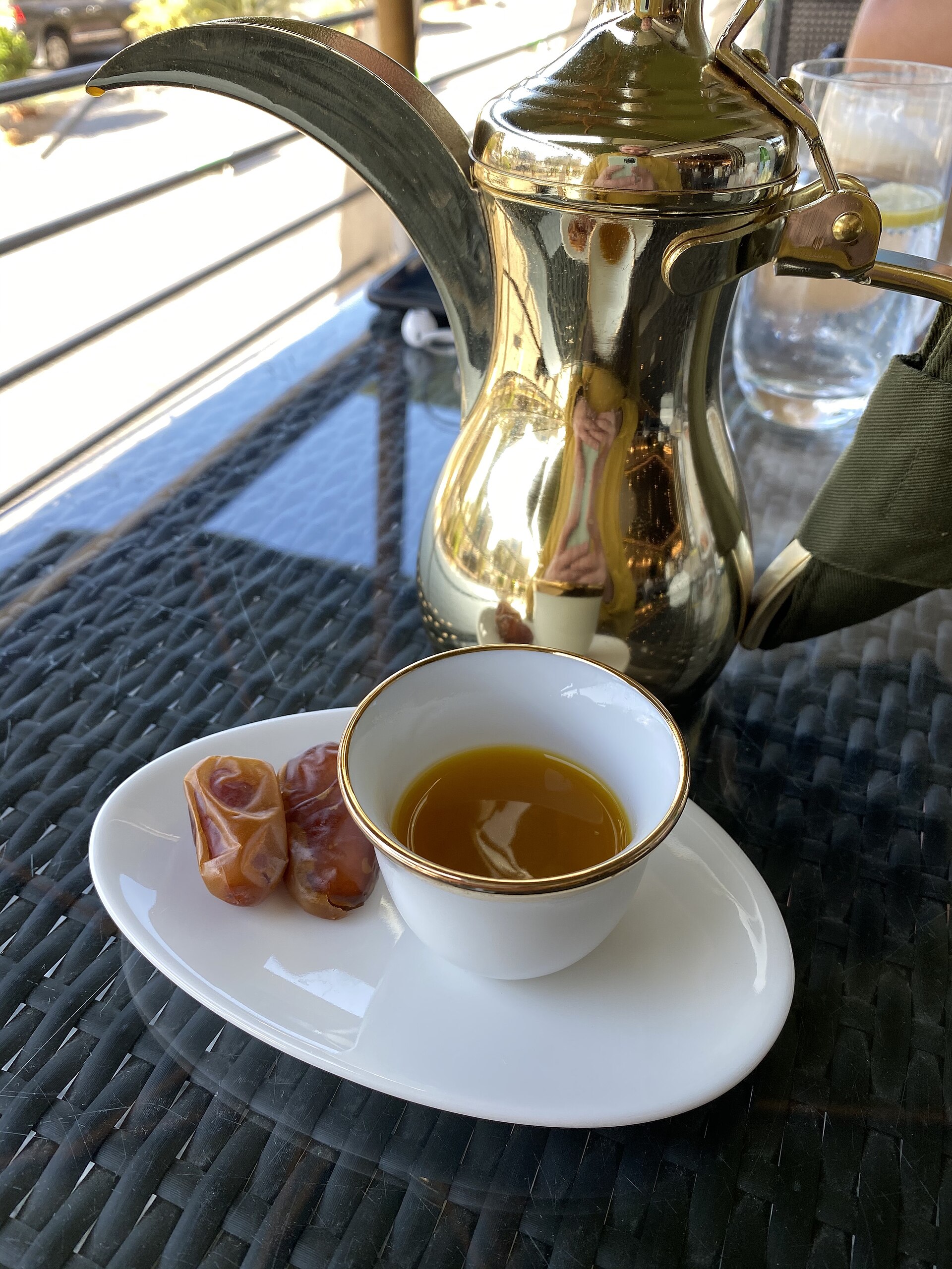 A real Arabic coffee dallah, a small saffron coffee cup and dates photographed together