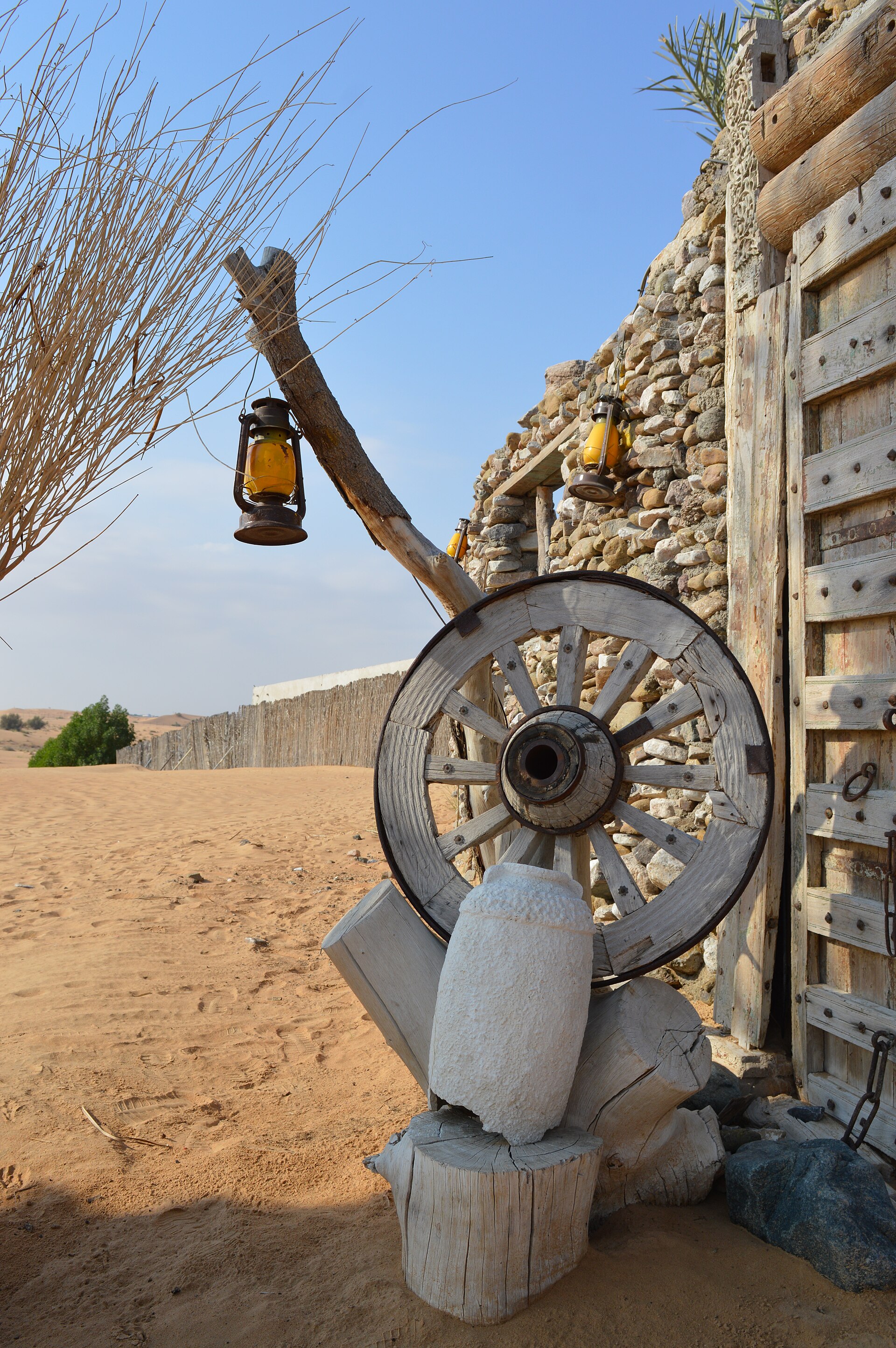 A real traditional lantern standing in desert sand under a clear blue sky